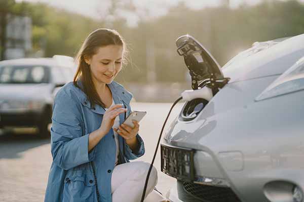 Electric Vehicle Woman Calculates Savings from No Carbon Offsets