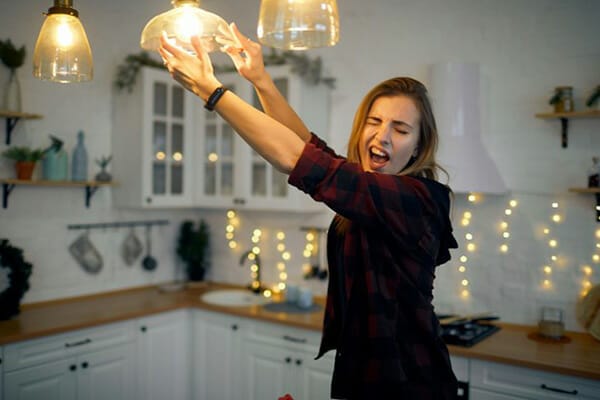 Woman Installs Energy-Efficient Light Bulb