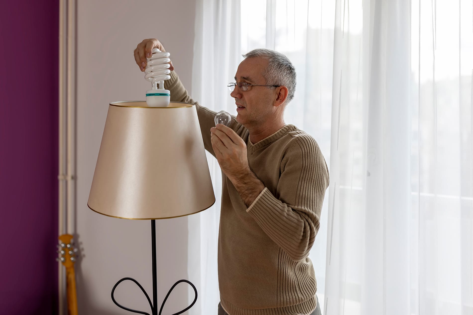 Energy Conservation in Daily Habits Man Changes Lightbulb